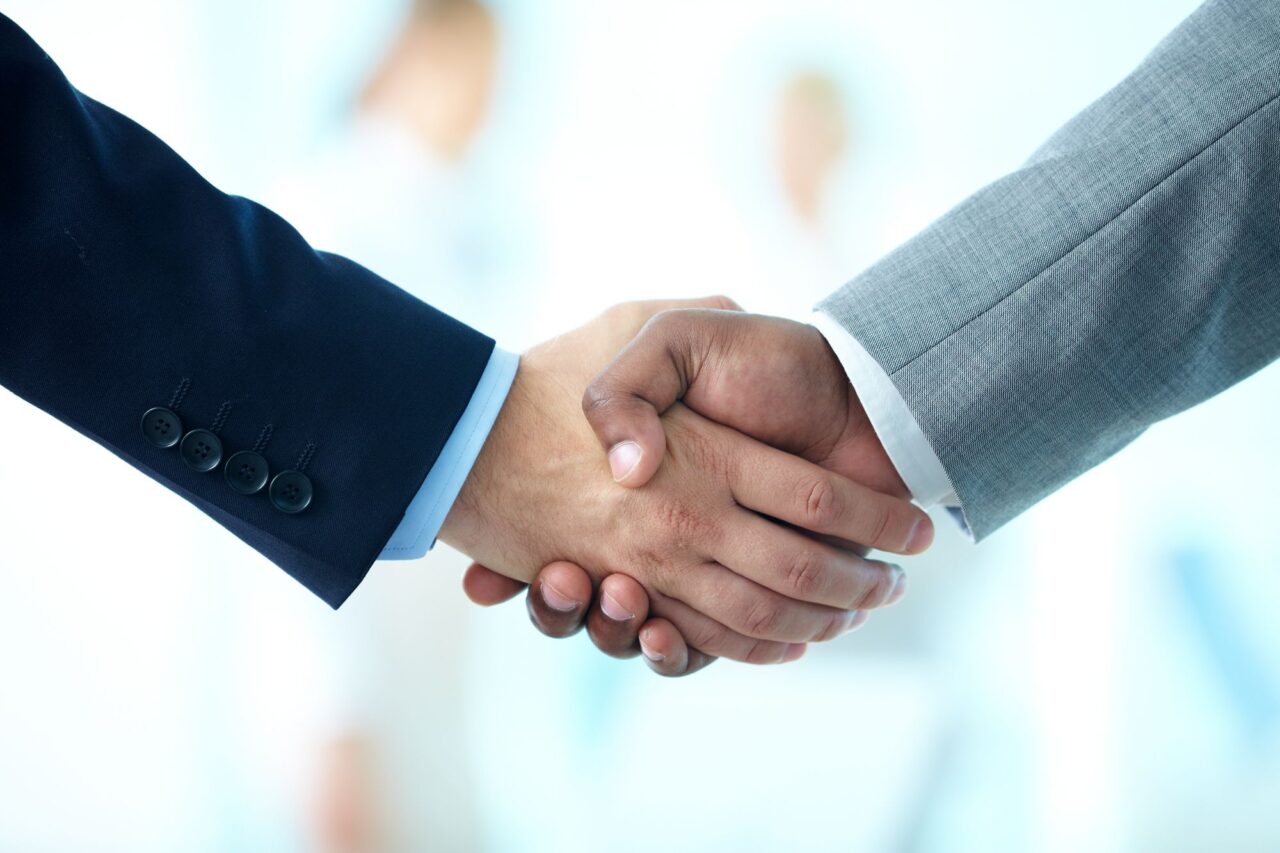 Twee handen die elkaar de handen schudden om hun partnerschap te bevestigen.