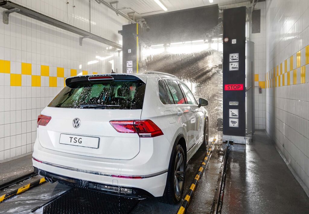Een witte wagen rijdt richting een roll-over van Kärcher, geïnstalleerd door TSG.