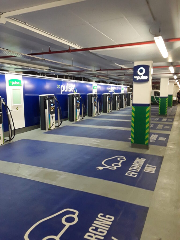 Ladepark für Elektrofahrzeuge mit mehreren Schnellladestationen in einem modernen Flottendepot.