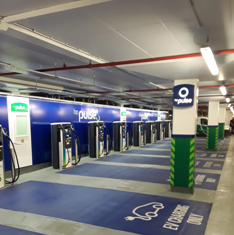 Ladepark für Elektrofahrzeuge mit mehreren Schnellladestationen in einem modernen Flottendepot.