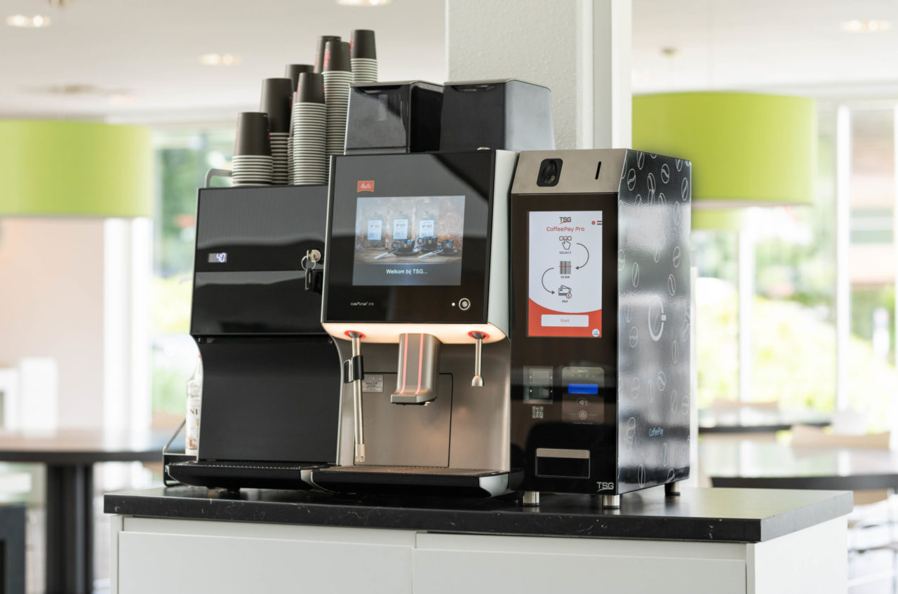 CoffeePay Pro op een toonbank, gekoppeld aan koffiemachine.