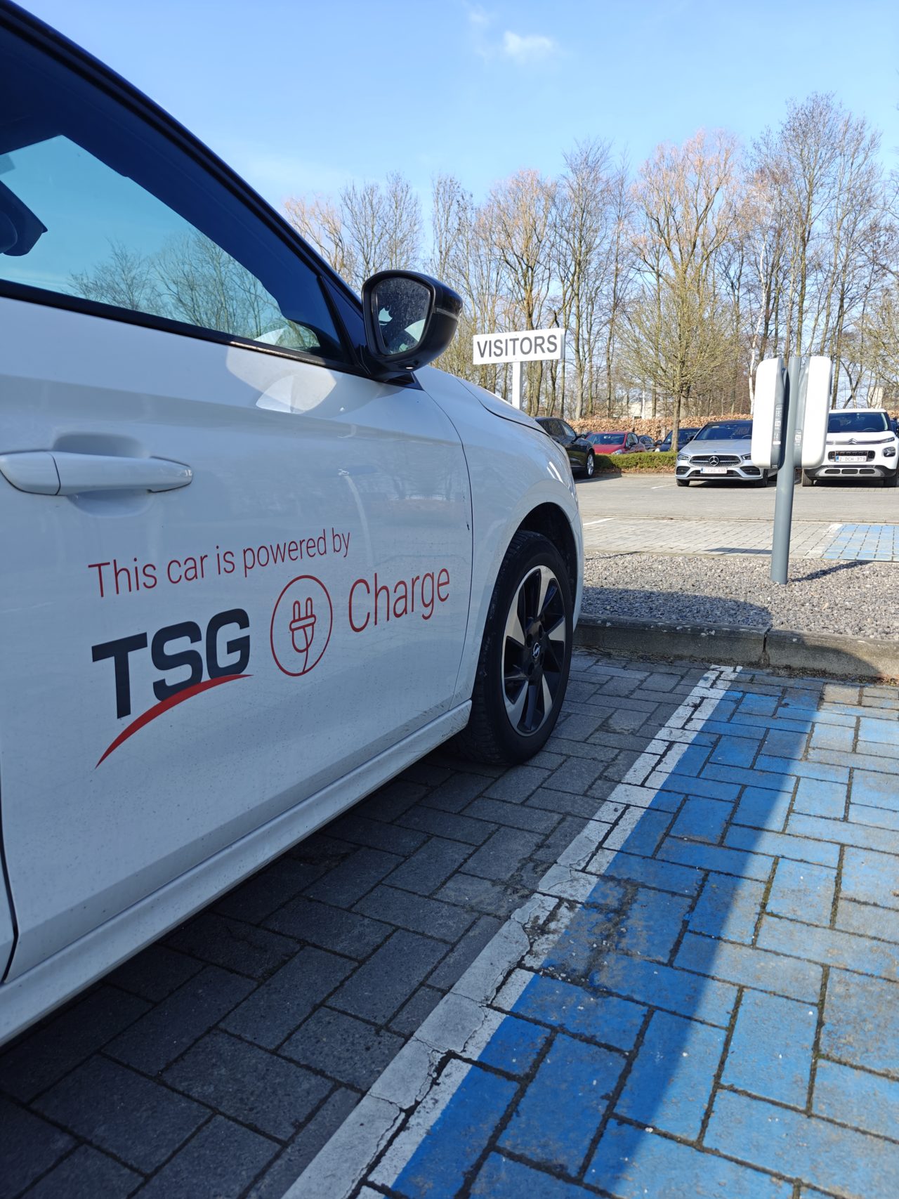 La voiture de TSG avec une borne de recharge de Shell Recharge au parking de Donaldson.