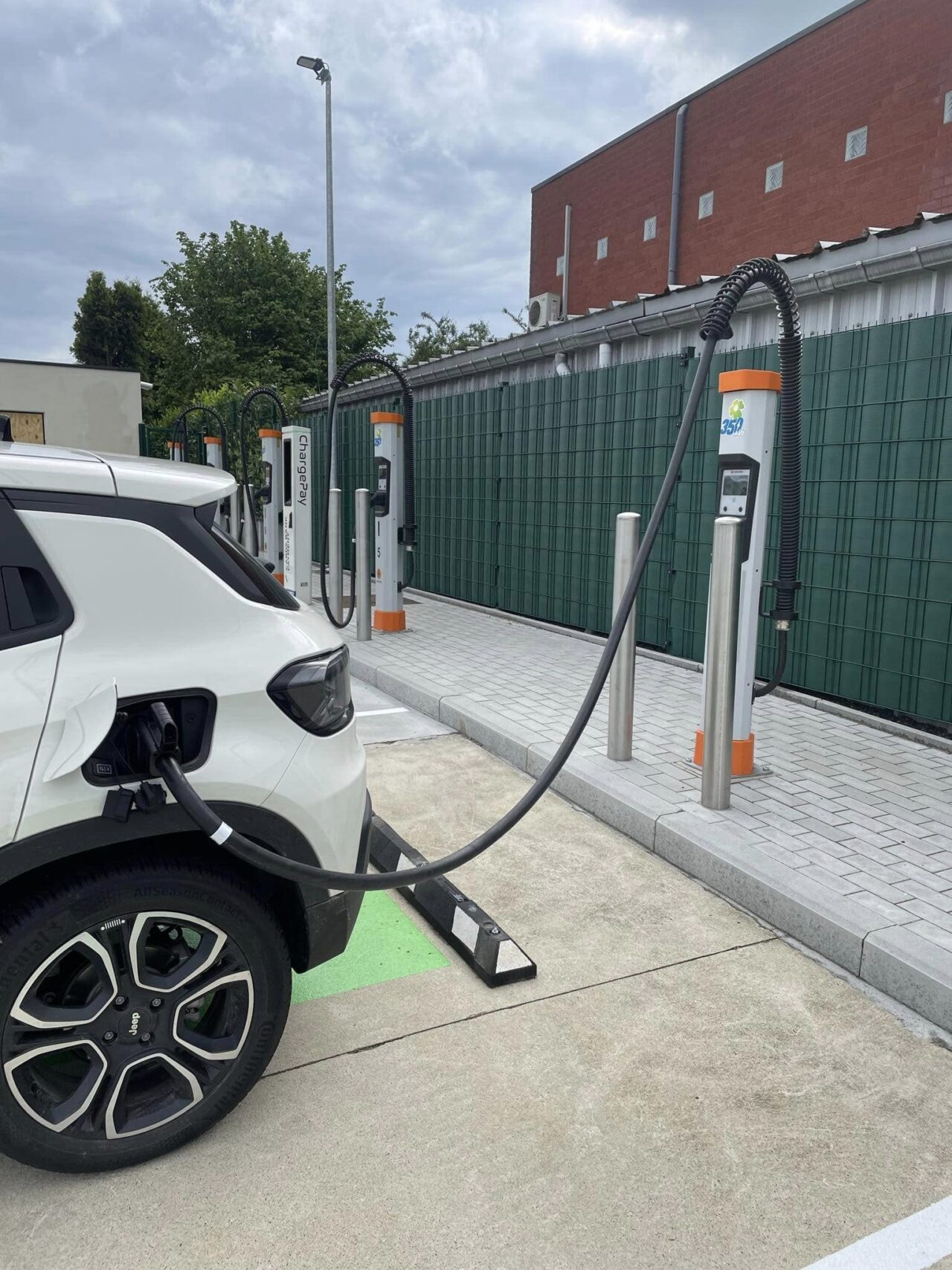 Une voiture blanche qui recharge à l'aide d'une borne de recharge DC de Kempower.