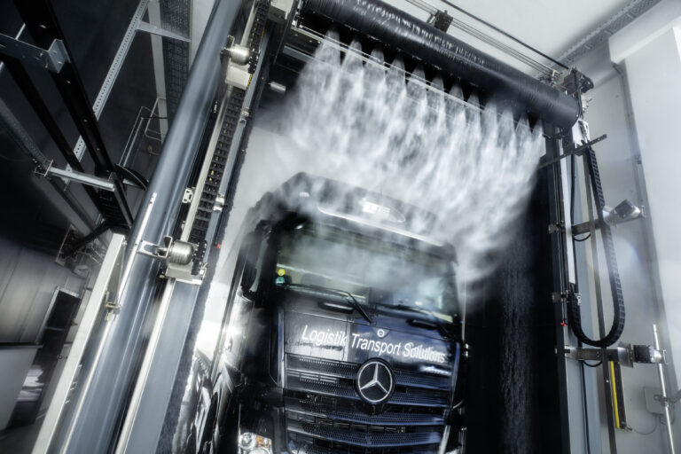 Vrachtwagen in een truckwash waarbij de hoge drukreiniger wordt gebruikt.