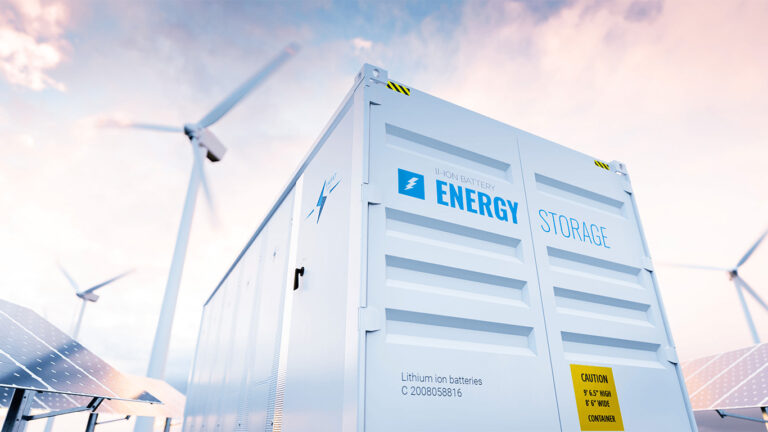 Een BESS, windmolens en zonnepanelen op een bedrijfsterrein.