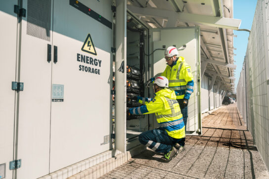 Twee techniekers van TSG Power die een volledige energieoplossing installeren. Op deze foto is de batterij energieopslag goed te zien.