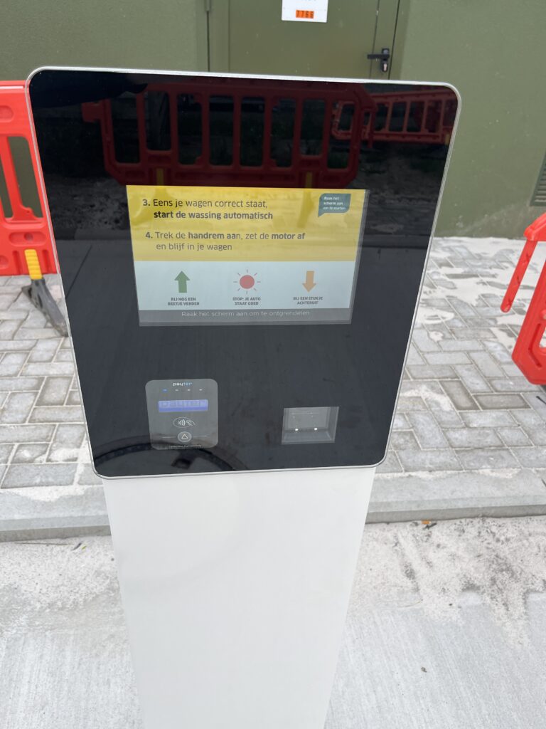 Close-up van de interface van de betaaloplossing CarwashPay die naast de gerenoveerde carwash staat.