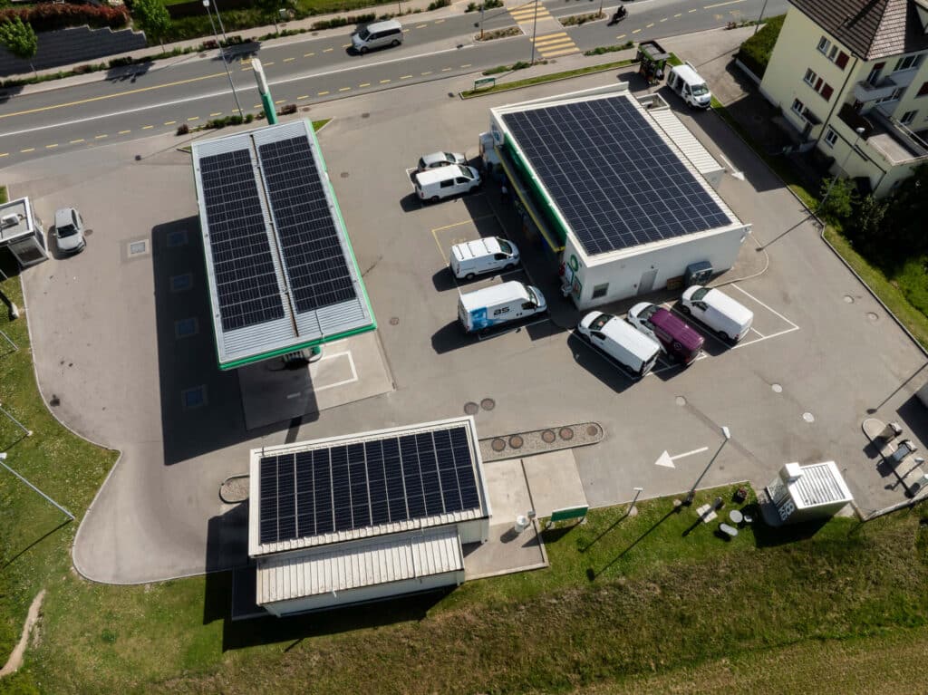 Luftaufnahme eines Unternehmensstandorts mit Photovoltaikanlagen und Ladeinfrastruktur zur effizienten Versorgung von Elektrofahrzeugen mit lokal erzeugter Energie