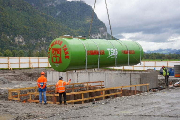 Pose d’une cuve à carburant à double paroi par grue lors de la construction d’une station-service